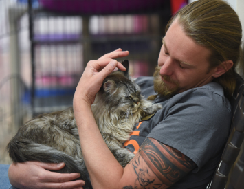 Man cuddling cat