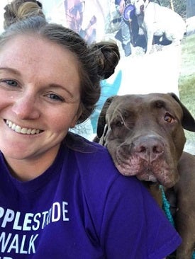 Woman with big dog resting its head on her shoulder