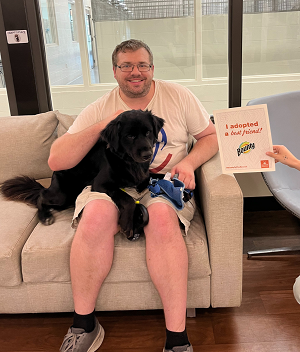 Man holding dog on couch in a shelter