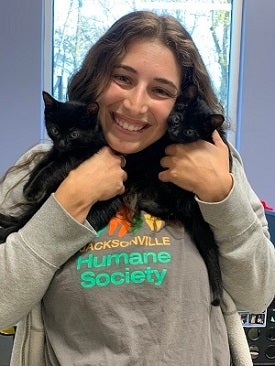 Woman holding two black kittens