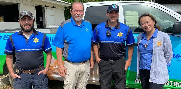 Shelter staff and BF staff member standing in front of truck